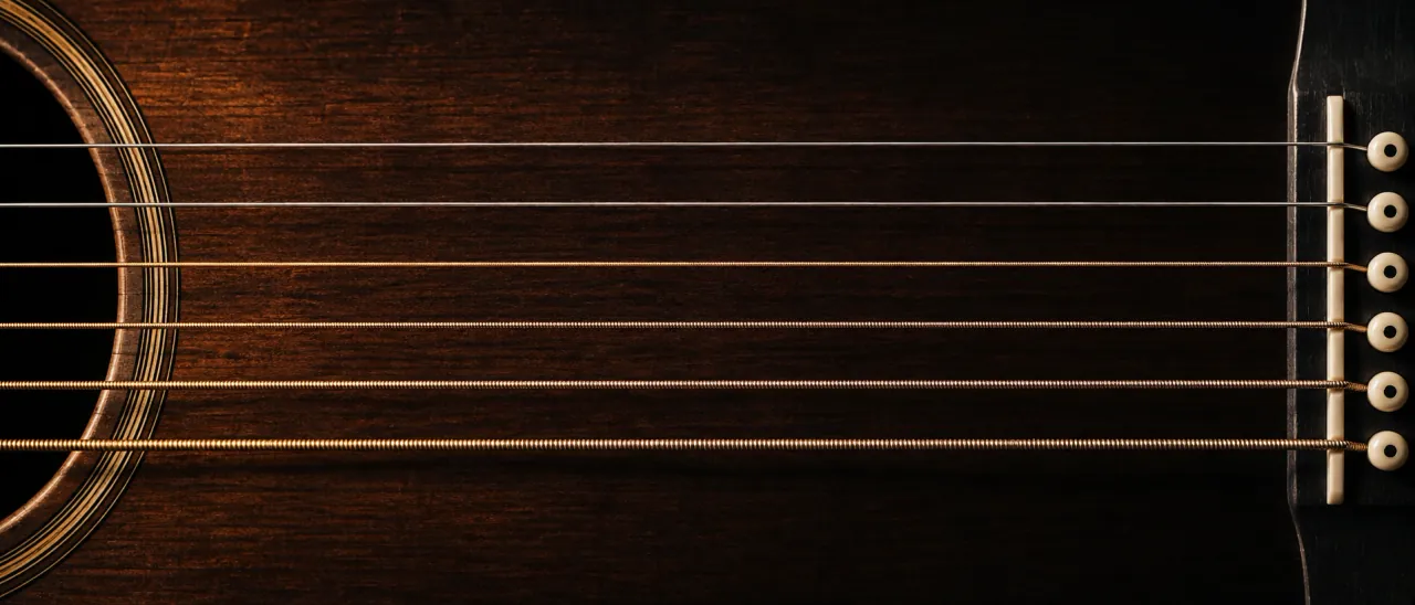 A generated image of six steel guitar strings crossing the dark top of an acoustic guitar, each labelled with its note name